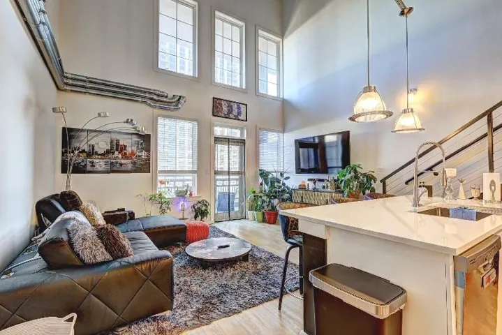 Living area with light wood-type flooring and a high ceiling