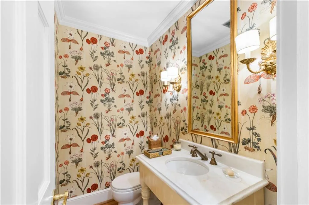 Bathroom featuring vanity, toilet, and crown molding