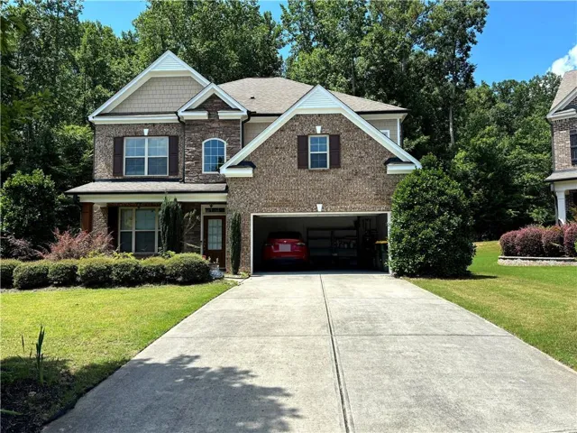 Two-story residence featuring a brick and stone facade with shake accent siding