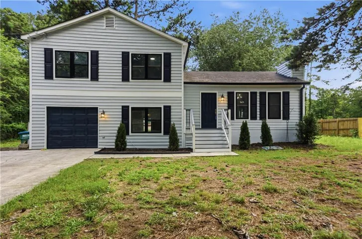Light gray siding exterior with dark shutters and black framed windows