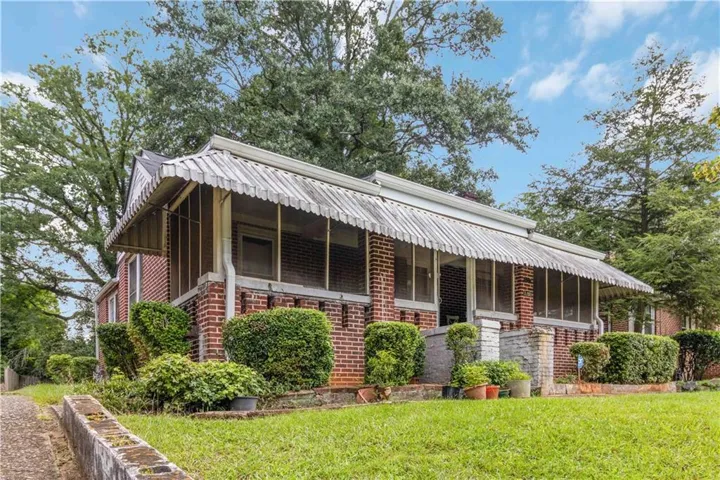 Brick exterior with a screened porch and awnings