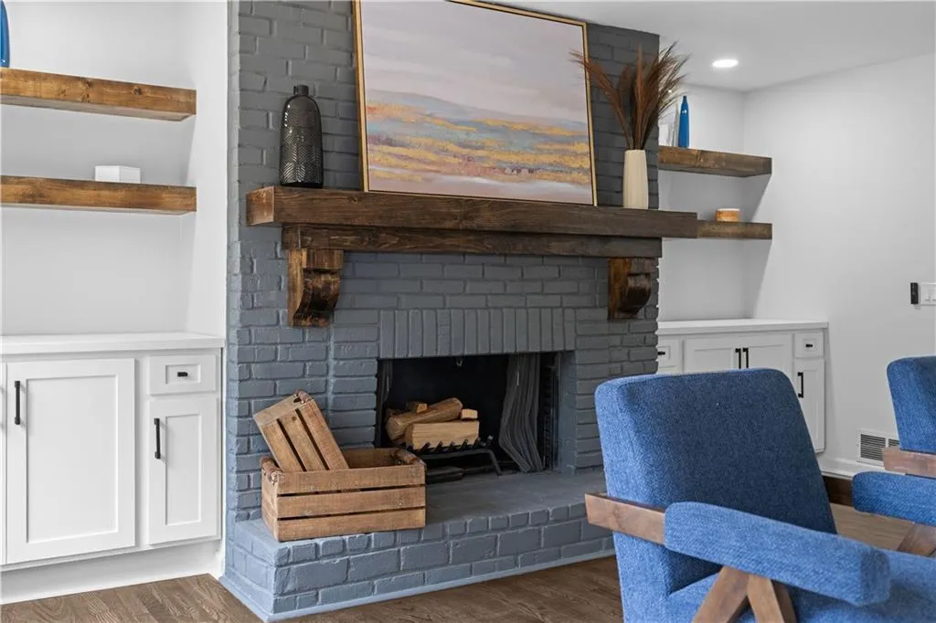 Living room featuring dark wood-type flooring and a brick fireplace