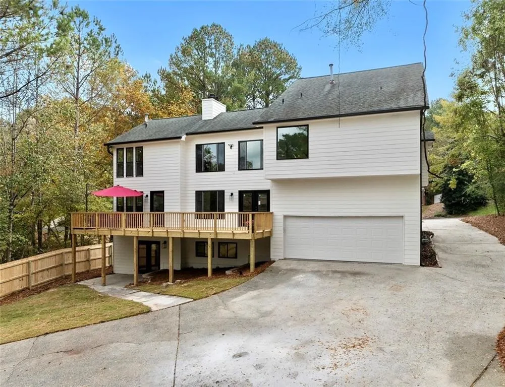 Rear view of property with a garage and a deck