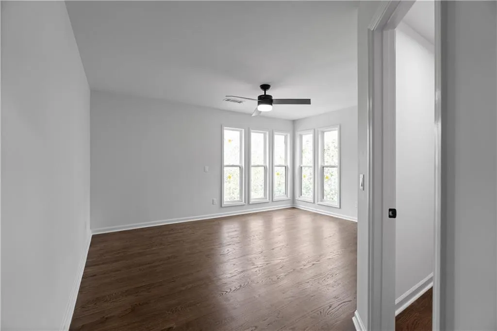 Unfurnished room featuring ceiling fan and dark hardwood / wood-style flooring