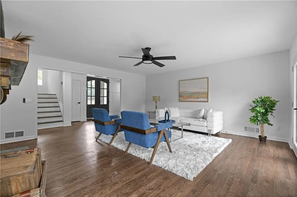 Living room with french doors, dark hardwood / wood-style flooring, and ceiling fan