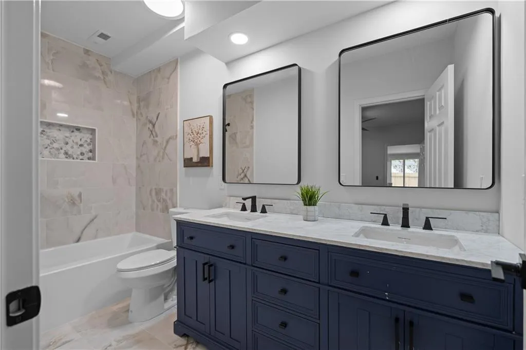 Full bathroom with vanity, toilet, and tiled shower / bath combo