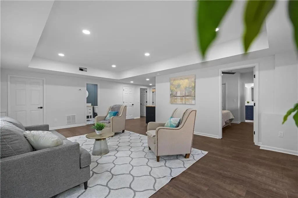 Living room with hardwood / wood-style floors and a raised ceiling