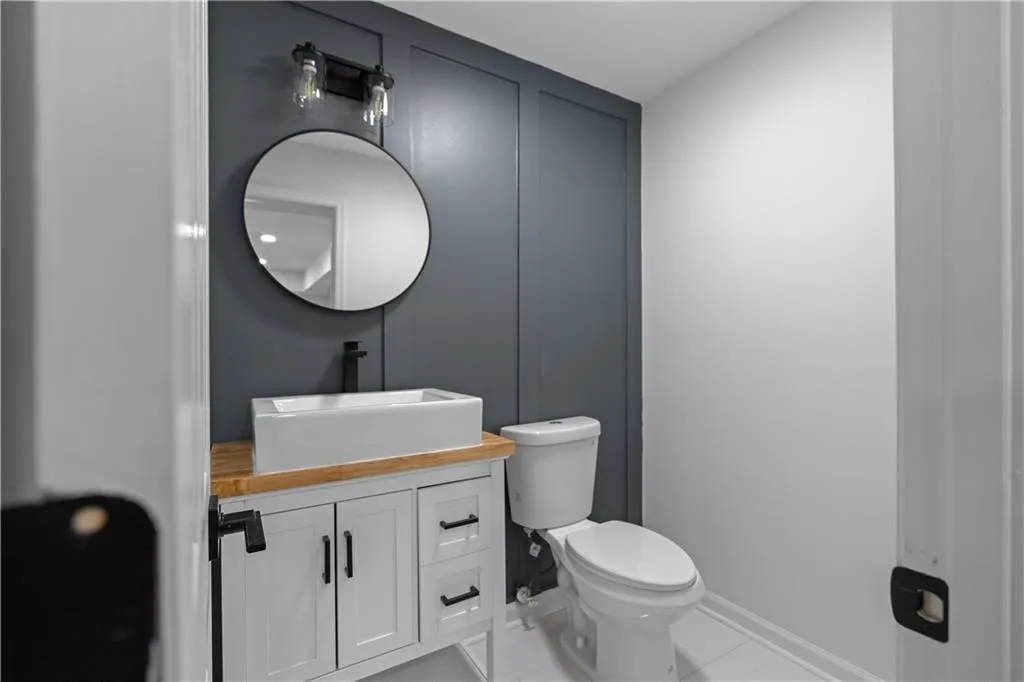 Bathroom featuring tile patterned flooring, vanity, and toilet