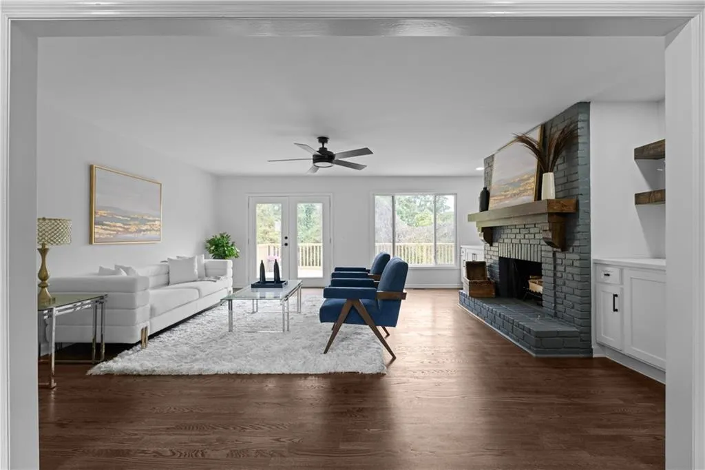 Living room featuring a brick fireplace, dark hardwood / wood-style floors, and ceiling fan