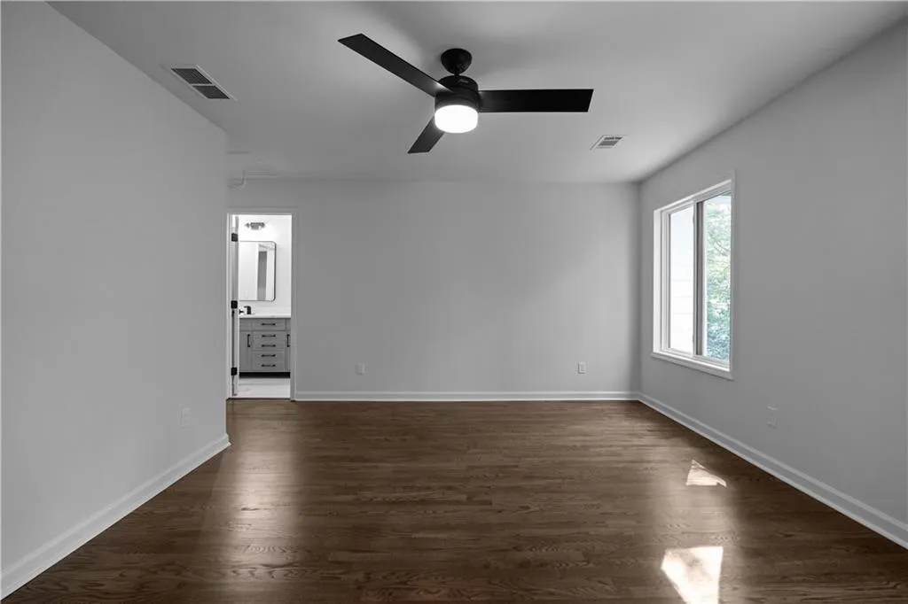 Spare room featuring dark hardwood / wood-style floors and ceiling fan