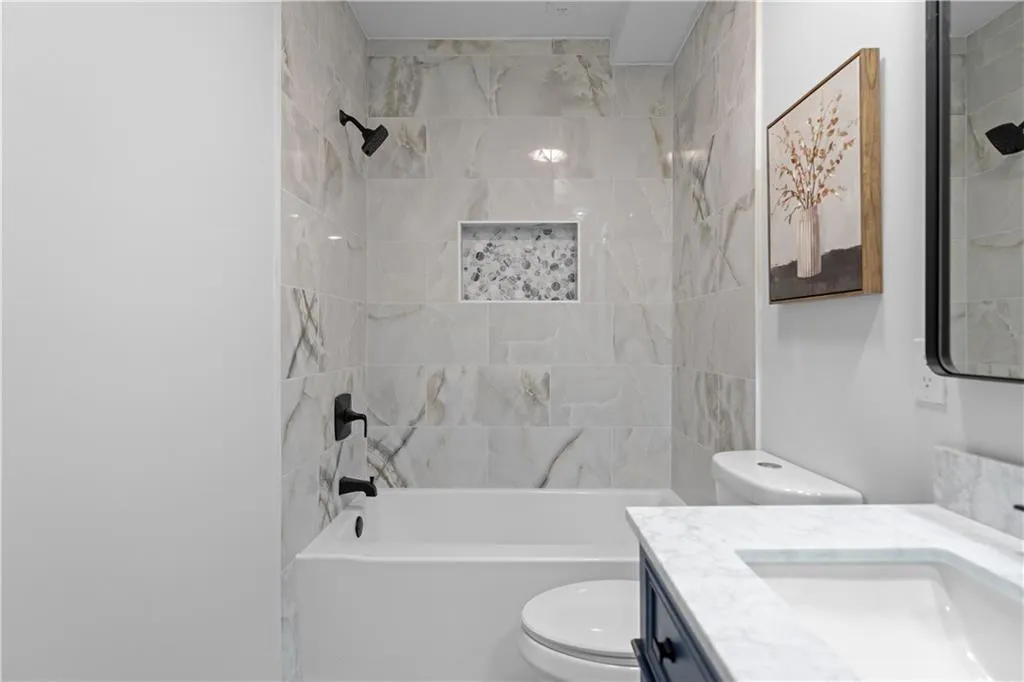 Full bathroom featuring vanity, toilet, and tiled shower / bath