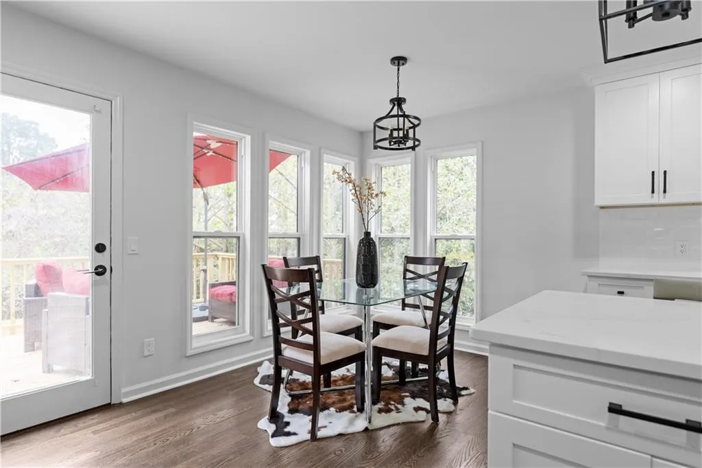 Dining space with dark wood-type flooring and an inviting chandelier