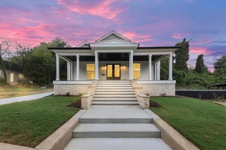 White siding exterior with a covered porch and stone accents