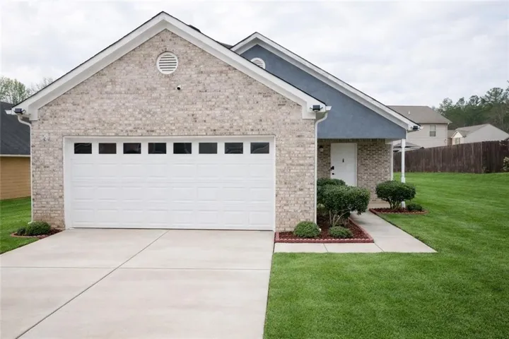 Single story home with brick siding, driveway, and a garage