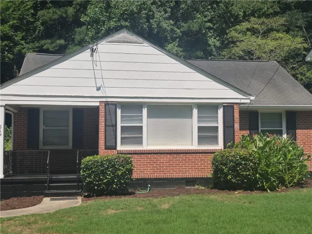 Brick exterior with white siding accents and a covered front porch featuring black railings