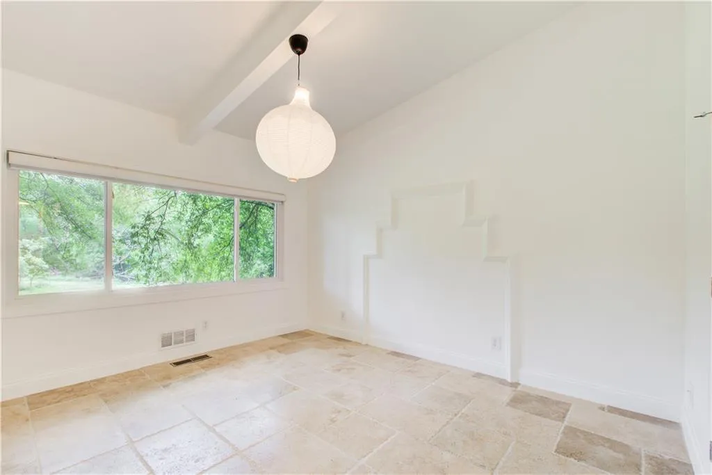 Spare room featuring baseboards and light stone finish flooring