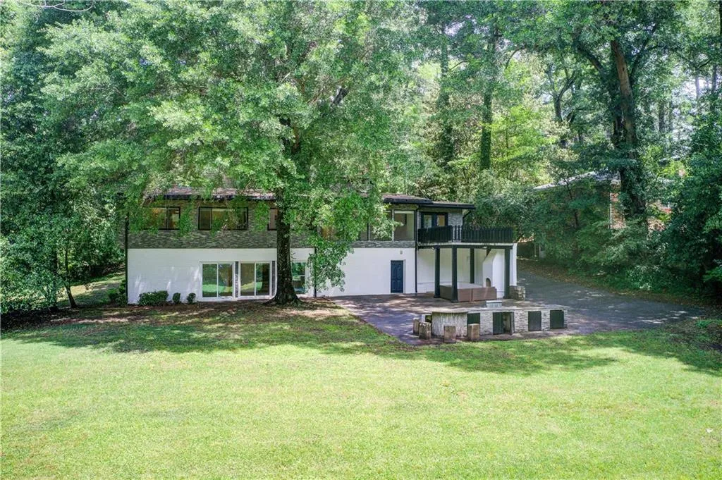 Rear view of house featuring a lawn and a patio