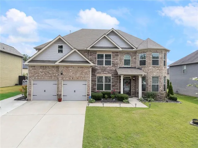 Two-story residence featuring a brick and siding exterior with a shingled roof