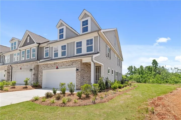 Townhome exterior with grey siding and stone veneer accents