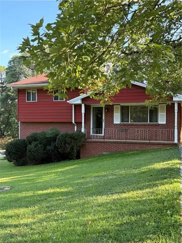 Red siding exterior with a brick foundation