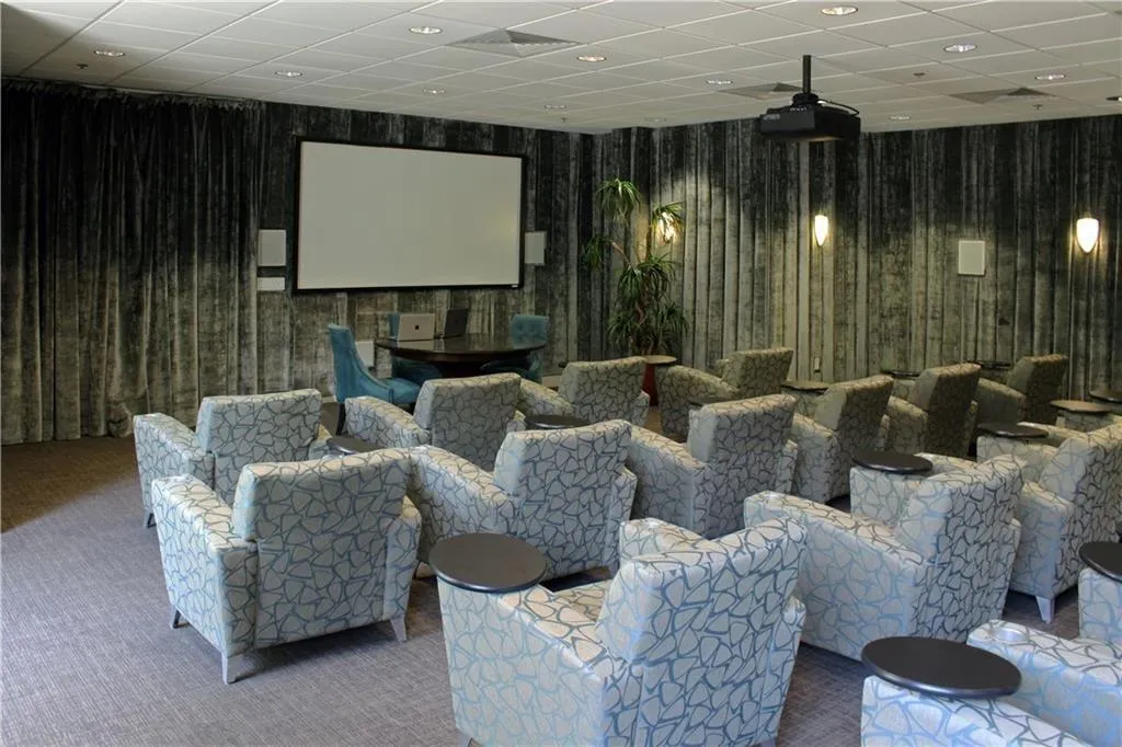 Carpeted cinema with wood walls, a drop ceiling, and recessed lighting