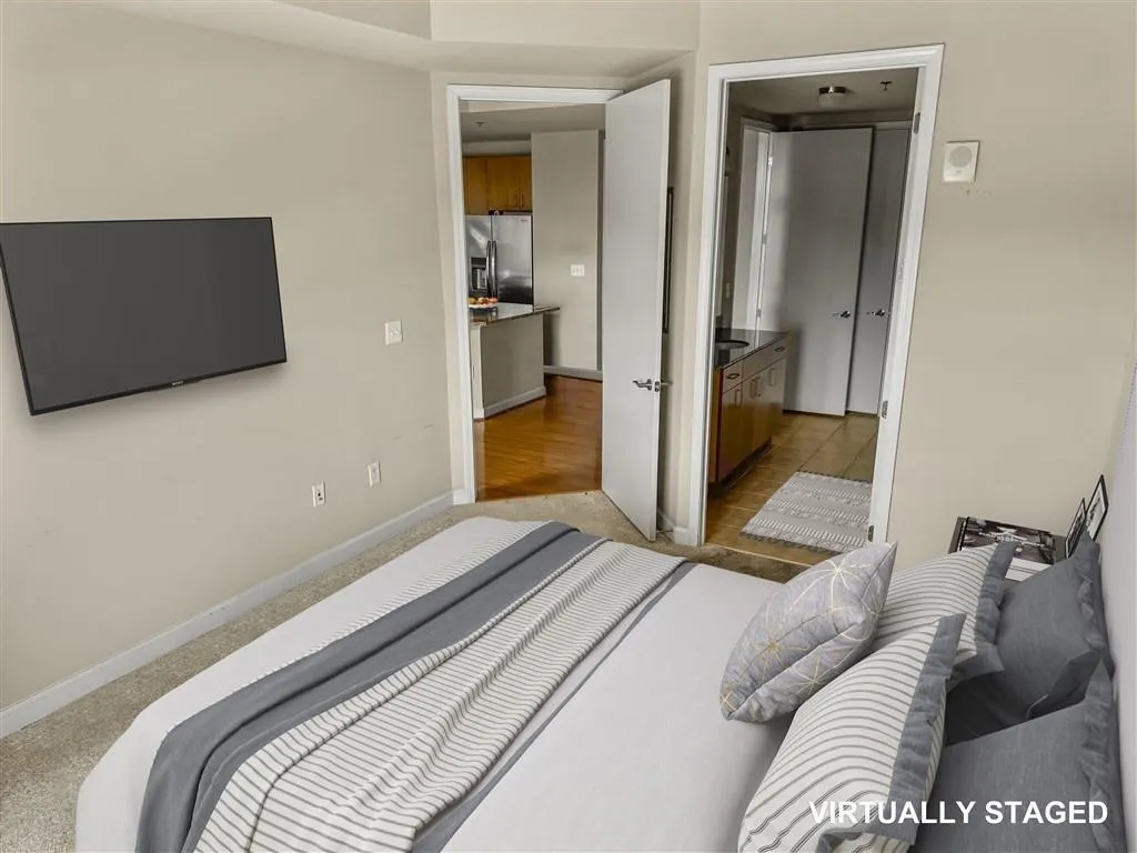 Bedroom with stainless steel refrigerator with ice dispenser and baseboards