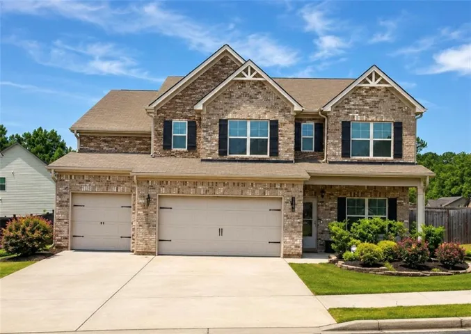 Brick facade home with a two-car garage and an additional single-car garage