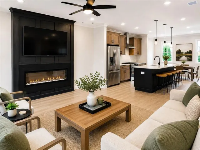 Photo is virtually staged. Spacious family room features a designer fireplace and an open-concept layout, creating the perfect space for relaxing, entertaining, and making lasting memories.