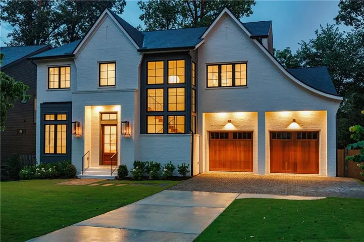 White brick exterior with dark trim and a prominent multi-pane window array