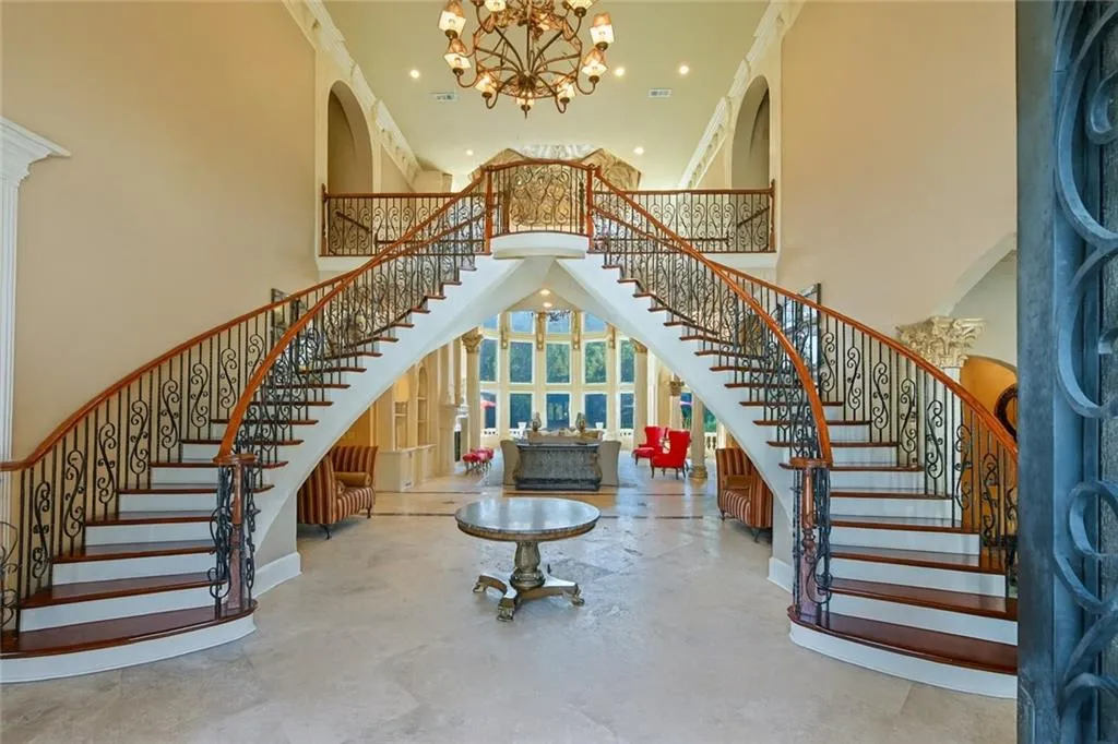 Foyer featuring a high ceiling, a chandelier, stairs, arched walkways, and recessed lighting