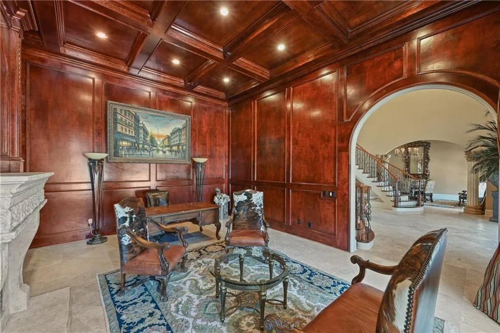 Office area featuring arched walkways, a wooden ceiling with exposed beams, coffered ceiling, a fireplace, and recessed lighting