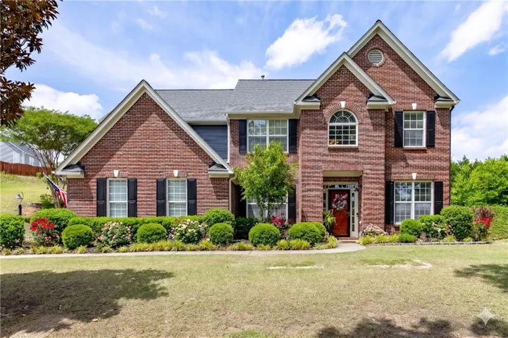 Traditional brick-front residence with a gabled roofline and dark shutters