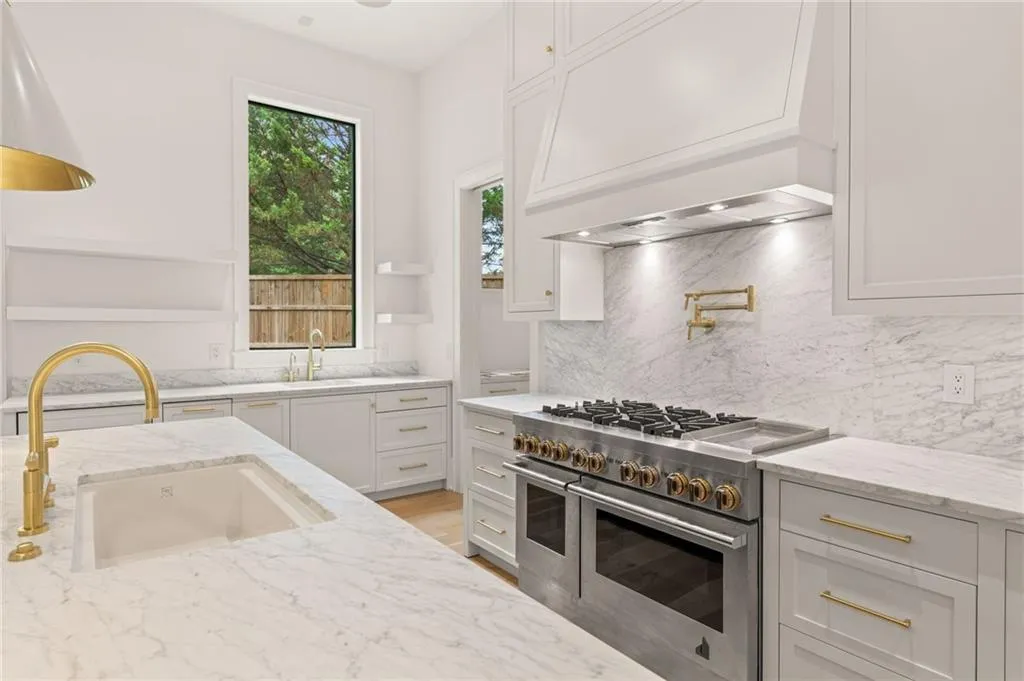 Gourmet kitchen featuring a professional-grade range, integrated double oven, and pot filler