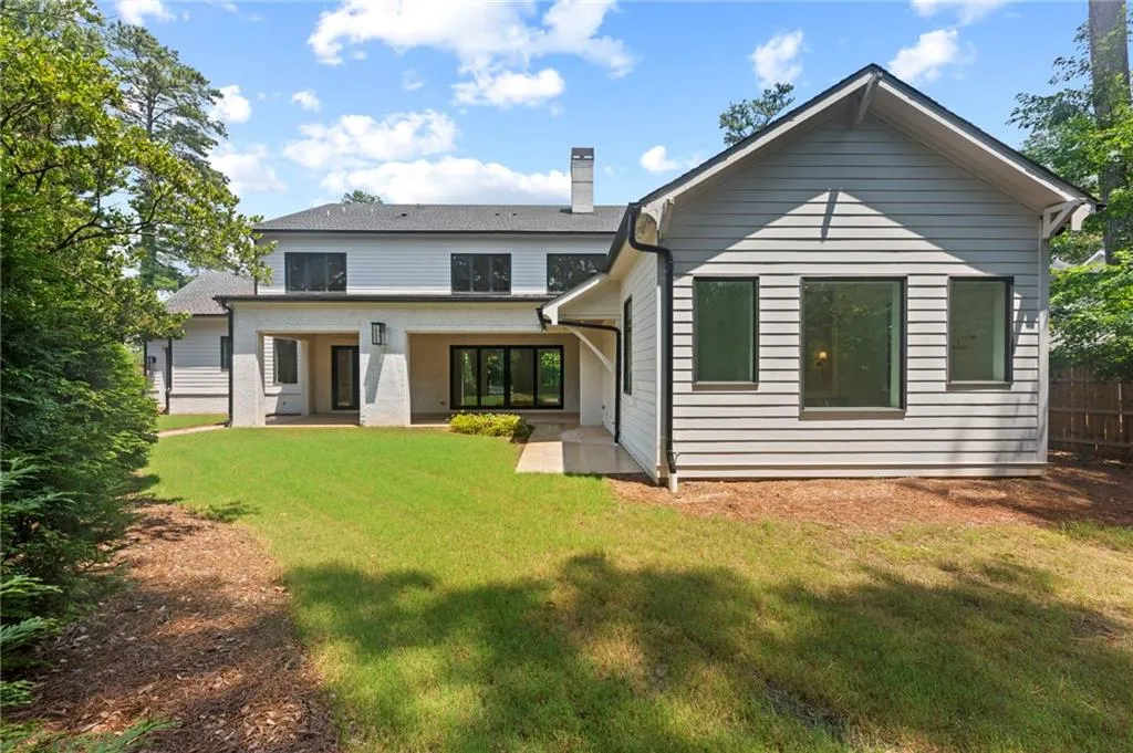 Expansive rear exterior featuring a covered patio, black-framed windows, and horizontal siding