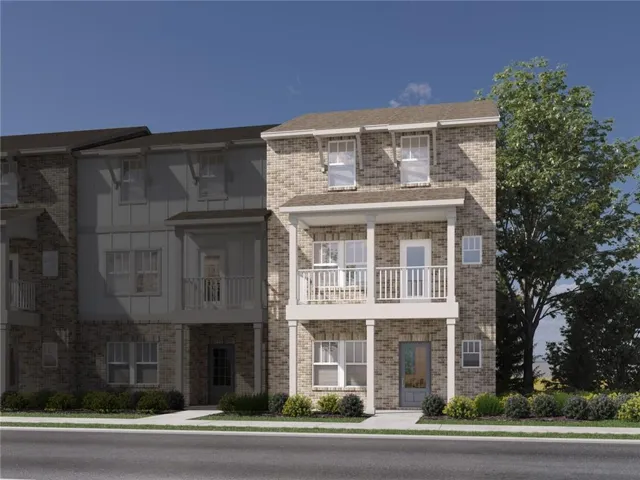 Brick facade townhome with a second-story balcony, covered entry, and dormer windows