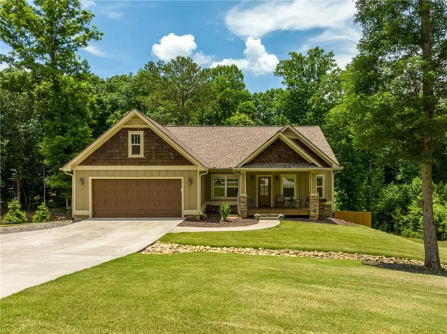 Craftsman-style exterior with a covered porch, stone column bases, and a prominent gable featuring shake siding