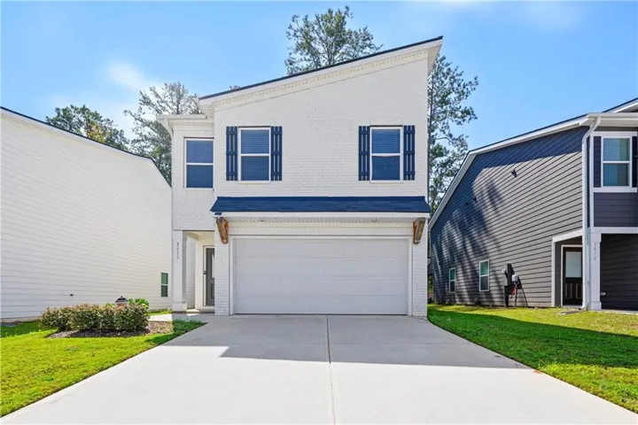 Contemporary two-story exterior featuring white brick and dark blue shutters