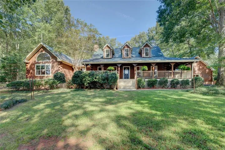 Cabin with a large porch and a front yard