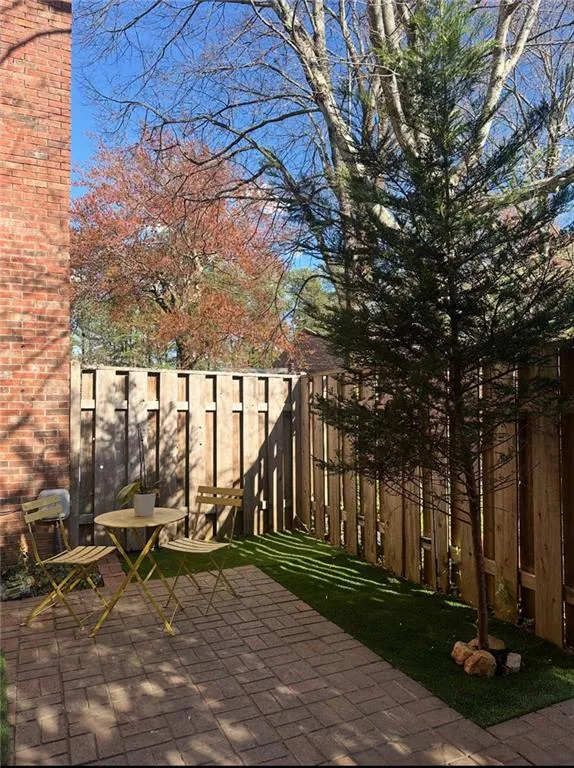 View of brick patio terrace featuring fence