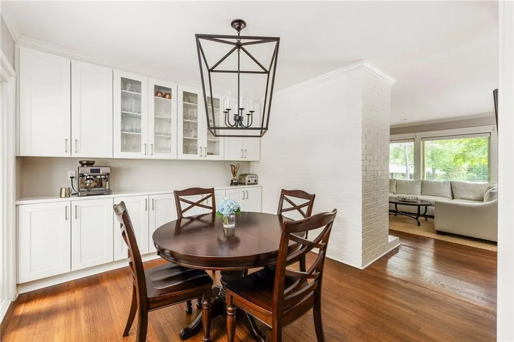 Dining room featuring brick wall, dark wood-type flooring, and ornamental molding