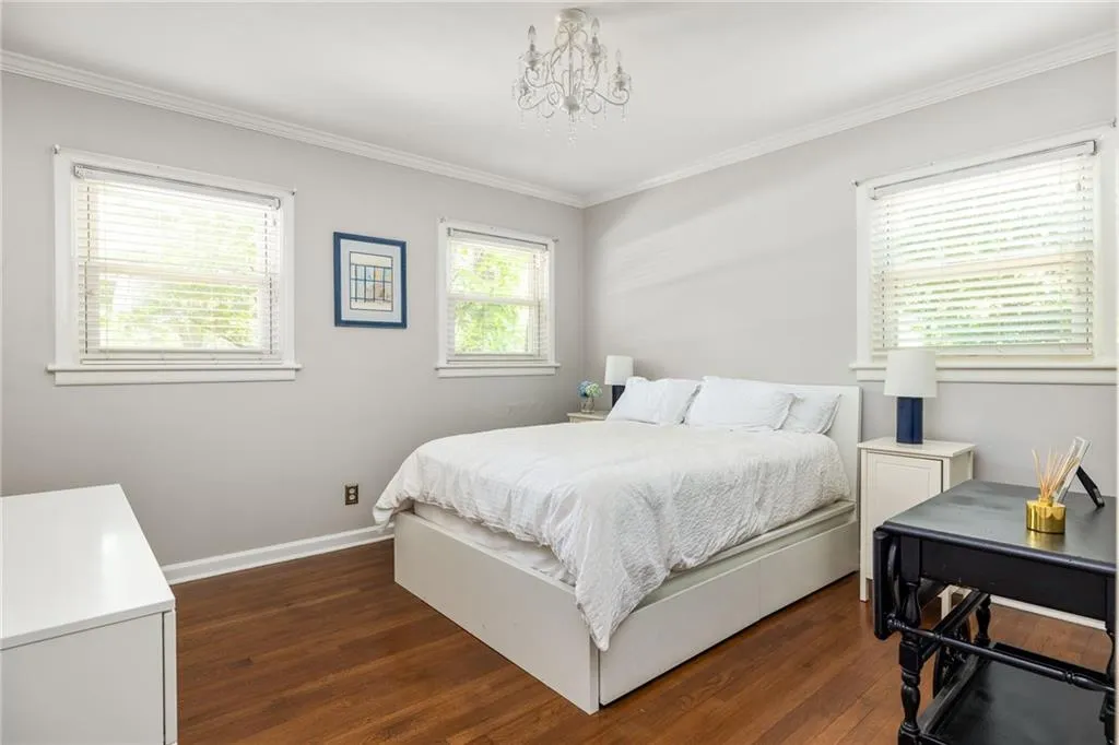 Bedroom with crown molding, dark hardwood / wood-style floors, and multiple windows