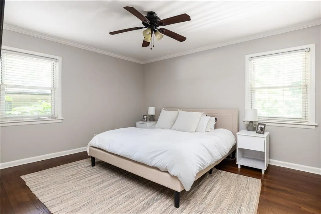 Bedroom featuring ceiling fan, hardwood / wood-style floors, and crown molding