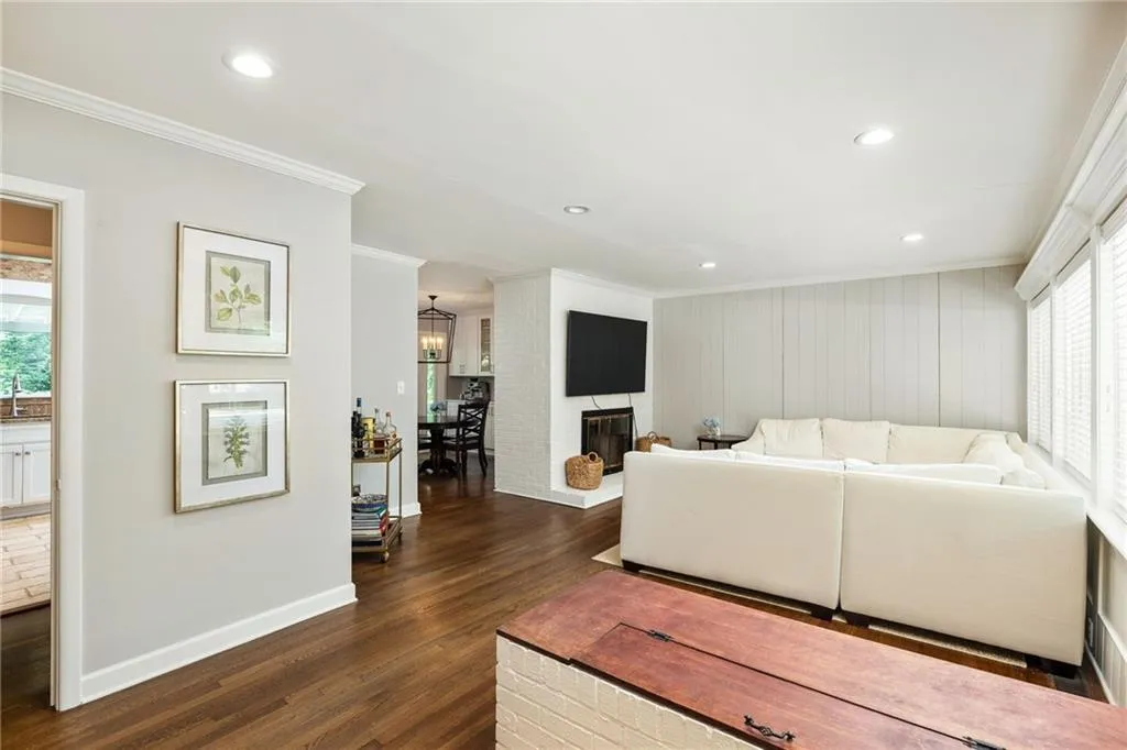 Living room featuring ornamental molding, dark hardwood / wood-style flooring, a wealth of natural light, and a fireplace