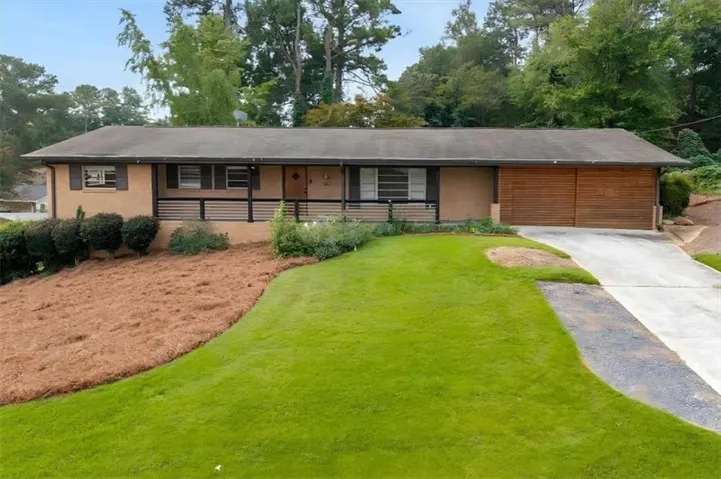 Brick exterior with horizontal wood paneling, covered front porch with dark railing, and an integrated two-car garage with wood-finish doors