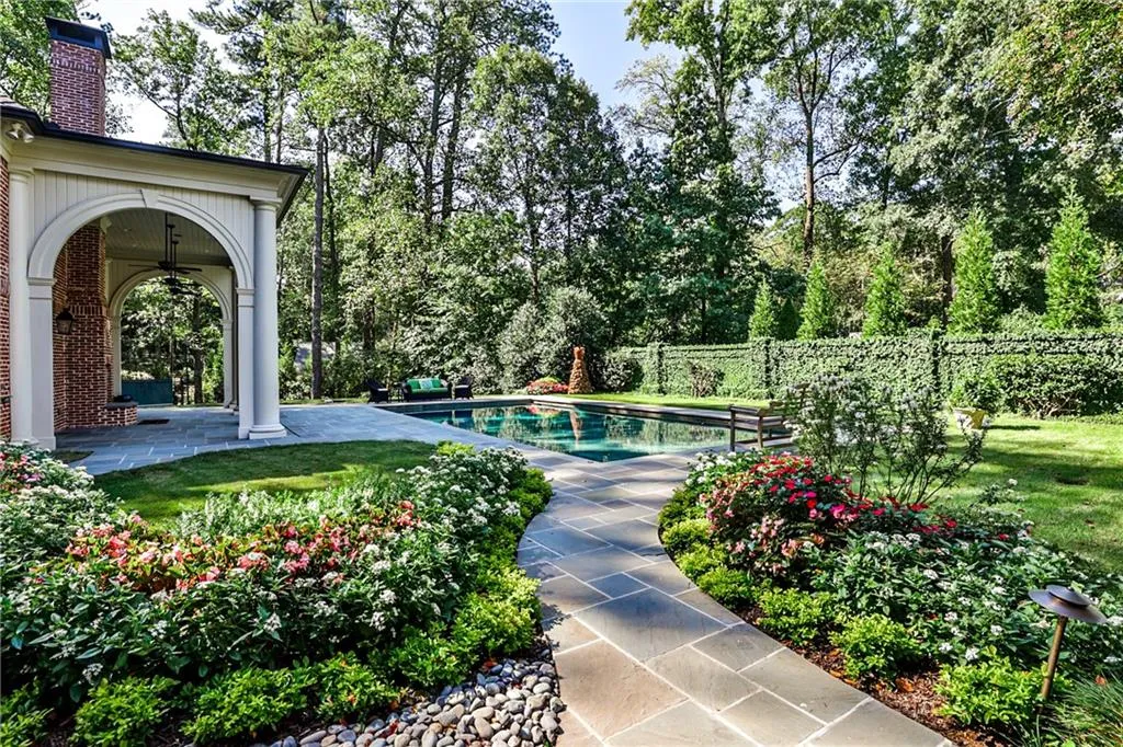 View of pool with a patio area and view of wooded area