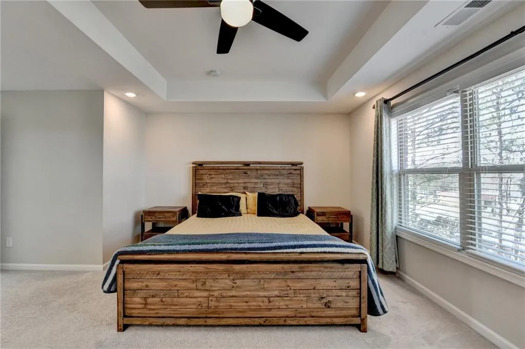 Bedroom with visible vents, baseboards, and light colored carpet