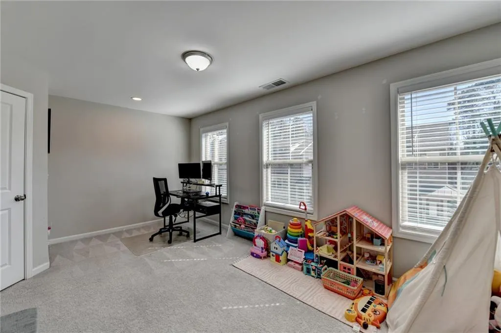 Recreation room featuring carpet floors, visible vents, and baseboards