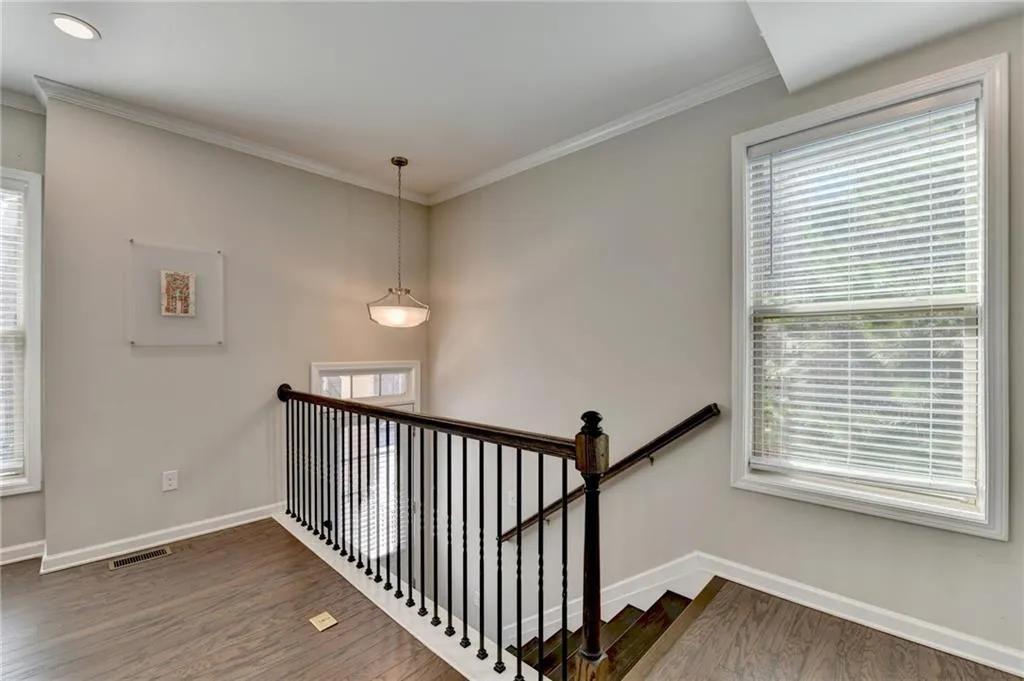 Stairway with plenty of natural light, baseboards, and wood finished floors