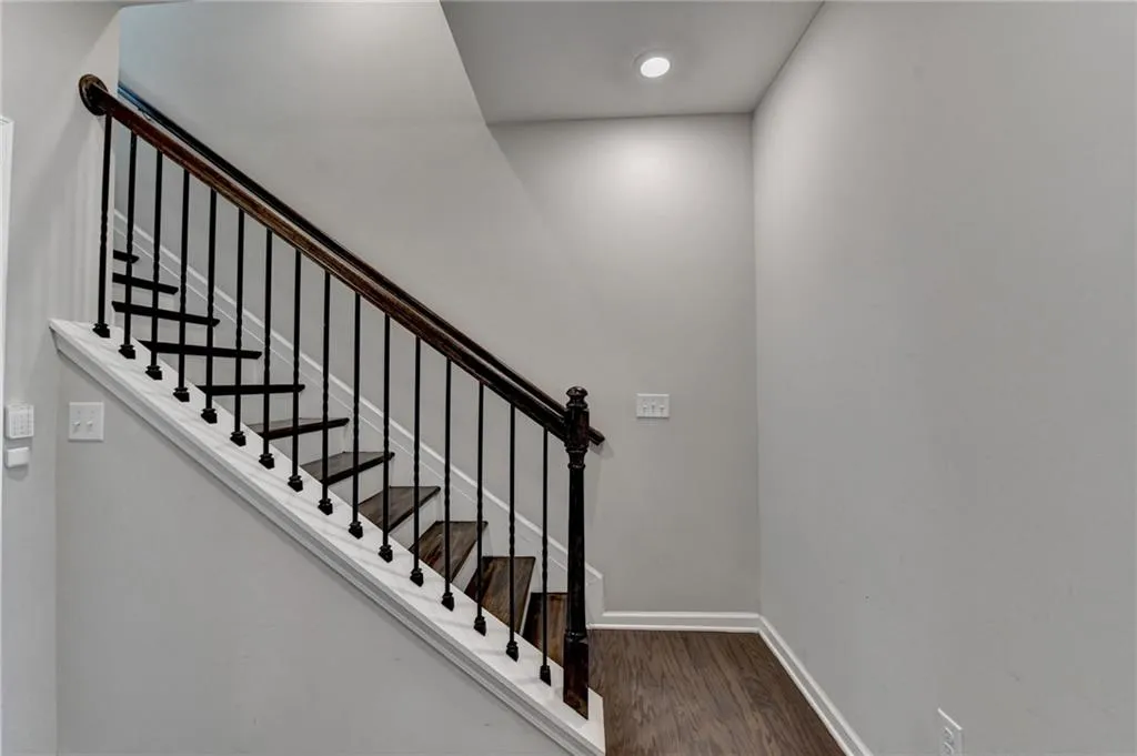 Staircase with baseboards and wood finished floors