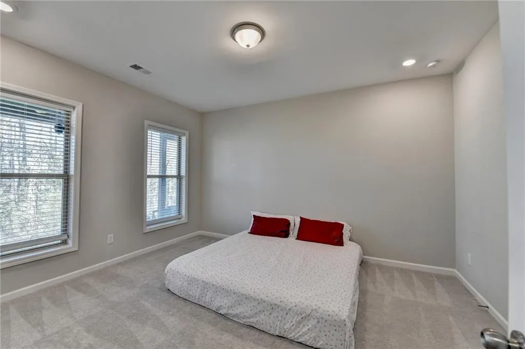 Bedroom with carpet, visible vents, and baseboards